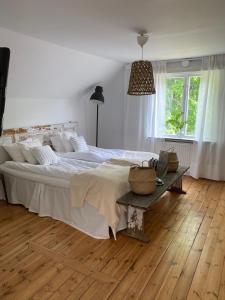 1 dormitorio con 1 cama grande y suelo de madera en Marys Cafe & Butik, en Vallby