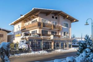 um grande edifício com neve no chão em Pension Schenkenfelder em Bad Häring