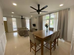 a dining room table with chairs and a ceiling fan at Casa Hijau in Kampung Pasir Kota