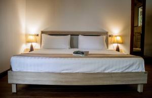 Una cama con dos almohadas y un libro. en Gecko Lipe Resort en Ko Lipe