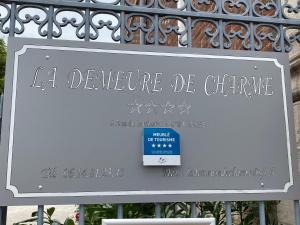 um sinal na frente de uma cerca de metal em La Demeure De Charme em Troyes