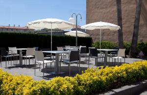 a group of tables and chairs with umbrellas at Hotel Bulevard in Benicàssim