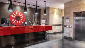 a lobby with a red counter in a building at Be Live City Center Talavera in Talavera de la Reina