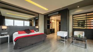 Un dormitorio con una cama, una mesa y una silla. en Be Live City Center Talavera, en Talavera de la Reina