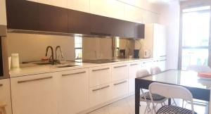 eine Küche mit weißen Schränken und einer schwarzen Arbeitsplatte in der Unterkunft Apartment on the Boulvard in Krakau