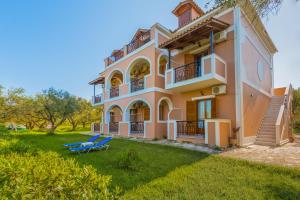 a large house with a lawn in front of it at Kavos Psarou Studios & Apartments in Alykes