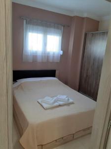 a bed with two towels sitting on top of it at Kosmos Service Apartment Modern Spirit City Center With Additional Cost Parking in Thessaloniki