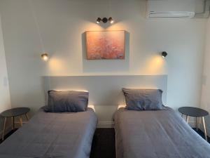 duas camas num quarto com duas mesas e um quadro em Doonside Hotel em Doonside