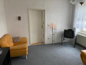 een woonkamer met een gele bank en een televisie bij Ferienwohnung Etgersleben in Etgersleben