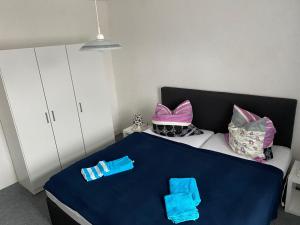 a bedroom with a bed with blue sheets and pillows at Ferienwohnung Etgersleben in Etgersleben