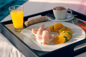 a tray with a plate of food and a glass of orange juice at Hotel Indigo Madrid - Gran Vía by IHG in Madrid