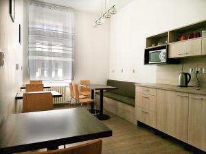 a kitchen with a table and some chairs and a counter at Hostel Vodna 1 in Košice