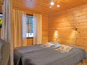 ユッラスヤルヴィにあるHoliday Home Kaltiotievantie 2 mökki 1 by Interhomeの木製の部屋にベッド1台が備わるベッドルーム1室があります。
