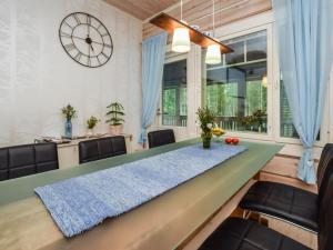 a dining room with a green table and chairs at Holiday Home Suviranta by Interhome in Suonenjoki