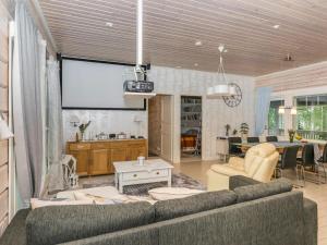 a living room with a couch and a large screen at Holiday Home Suviranta by Interhome in Suonenjoki