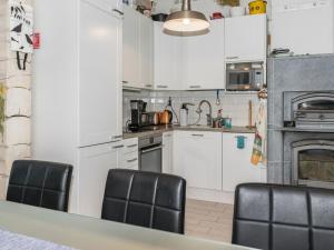 a kitchen with white cabinets and black chairs at Holiday Home Suviranta by Interhome in Suonenjoki +19 photos