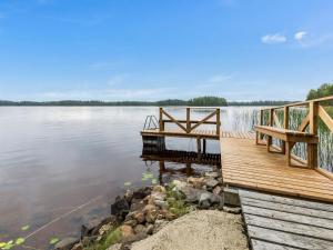 a dock on a body of water with a waterfall at Holiday Home Suviranta by Interhome in Suonenjoki