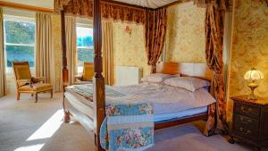 a bedroom with a canopy bed and a chair at Banoge House in Donaghcloney +27 photos
