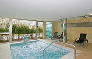 a hot tub in a room with chairs and windows at Riu La Mola in Playa Migjorn