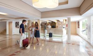 a group of people standing in a lobby with luggage at Riu La Mola in Playa Migjorn