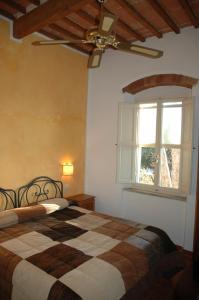 a bedroom with a bed with a ceiling fan and a window at Villa Terme Di Caldana B&B in Venturina Terme +31 photos