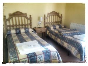 a bedroom with two beds with a sink in it at Hospedería Villa de Pintano in Pintano