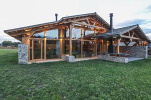 a house with a wooden roof on a grass field at Mountain Hawk Park in Razlog
