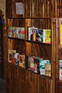 ein Bücherregal voller Bücher an einer Holzwand in der Unterkunft Kyaninga Royal Cottage in Fort Portal