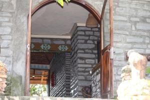 a mirror on a stone building with a doorway at Kyaninga Royal Cottage in Fort Portal