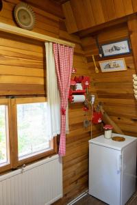 a kitchen with wooden walls and a refrigerator and a window at Ethno Cottage "Biljana" in Zlatibor +28 photos