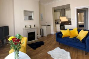 a living room with a blue couch and a fireplace at Mostyn Villa 2 in Llandudno