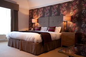 a bedroom with a large bed with a large headboard at The Townhouse Hotel in Melrose