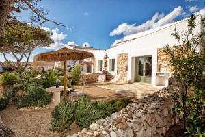 an external view of a house with a stone wall at Menorca Experimental in Alaior