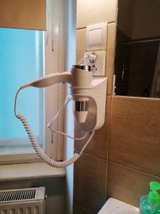 a bathroom with a hair dryer on the wall at Hostel Vodna 1 in Košice