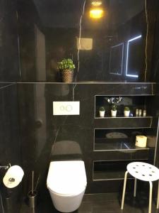 a bathroom with a white toilet and a black wall at Hotel Jadran in Split