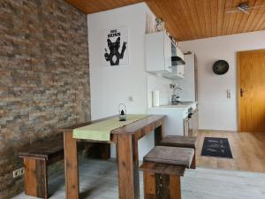 a kitchen with a table and benches in a room at Ferienwohnung Krähennest in den Hegaubergen - Nähe Bodensee in Mühlhausen-Ehingen