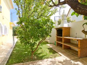 um jardim com um banco ao lado de uma árvore em Villa Villa Monte da Torre by Interhome em Alfarrobeira