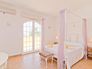 a bedroom with a canopy bed and a table at Villa Villa Monte da Torre by Interhome in Alfarrobeira