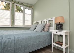 a bedroom with a bed and two windows at Anna Green House in Palanga