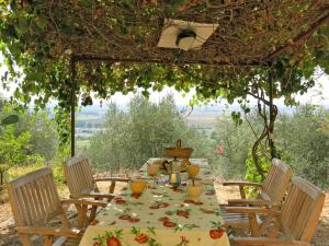 een tafel met stoelen en een tafel met een tafelkleed bij Holiday Home L'Uccelliera by Interhome in Il Prato