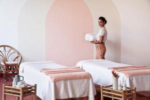 une femme debout dans une pièce avec deux lits dans l'établissement Menorca Experimental, à Alaior