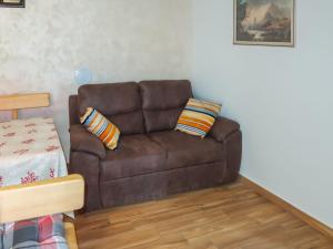 a brown couch with two pillows in a living room at Holiday Home Elija by Interhome in Mošćenička Draga
