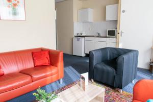 ein Wohnzimmer mit einem Sofa und einem Stuhl in der Unterkunft Hotel Lemmer in Lemmer