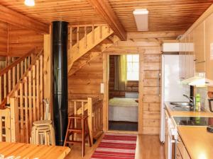 Cabaña de madera con cocina y escalera que conduce a un dormitorio en Holiday Home Hallanhelmi a paritalo by Interhome, en Hyrynsalmi