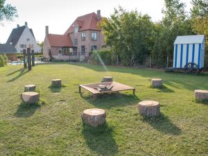 a park with a picnic table with logs and a fountain at Villa Villa Sas by Interhome in Oudenburg
