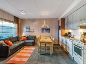 eine Küche und ein Wohnzimmer mit einer Couch und einem Tisch in der Unterkunft Holiday Home Rukatonttu d 14 by Interhome in Ruka