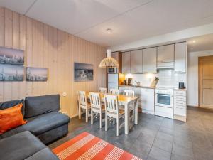 ein Wohnzimmer und eine Küche mit einer Couch und einem Tisch in der Unterkunft Holiday Home Rukatonttu d 14 by Interhome in Ruka