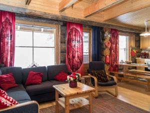 a living room with a blue couch and red curtains at Holiday Home Lumipolku a 1 by Interhome in Äkäslompolo