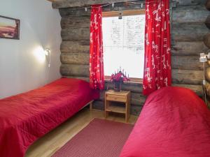 two red beds in a room with a window at Holiday Home Lumipolku a 1 by Interhome in Äkäslompolo