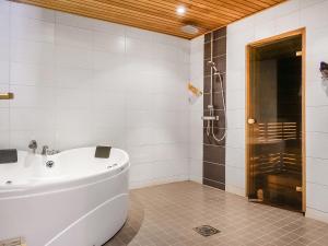 ein weißes Bad mit einer Badewanne und einer Dusche in der Unterkunft Holiday Home Lux iii by Interhome in Salla